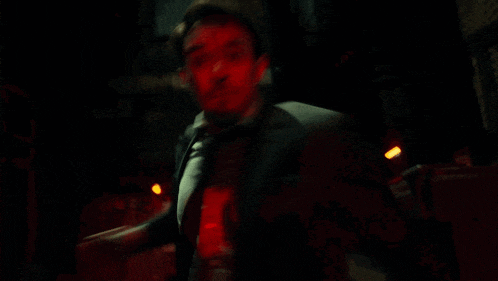 a blurry picture of a person in a dark room with a red light behind them .