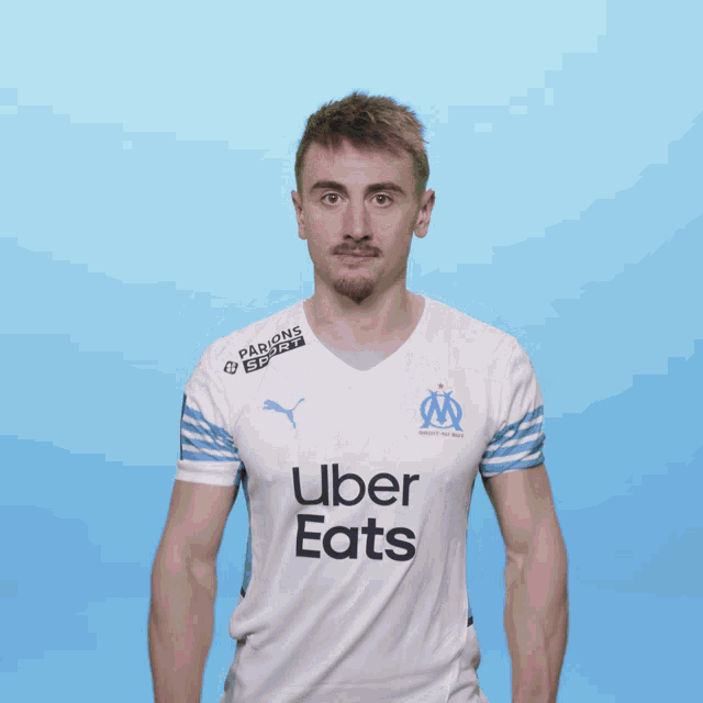a man is wearing an uber eats shirt and pointing