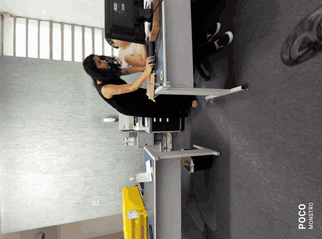 a woman sits at a desk in front of an aoc computer monitor