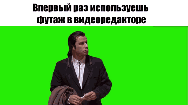 a man in a suit is standing in front of a green screen with russian writing on it
