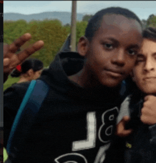 a boy wearing a black hoodie with the letter l on it poses for a photo