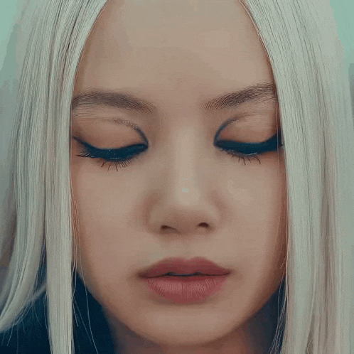 a close up of a woman 's face with white hair and a red lip
