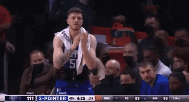 a basketball player with the number 5 on his jersey applauds