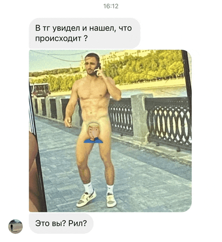 a man without a shirt is talking on a cell phone while standing on a sidewalk