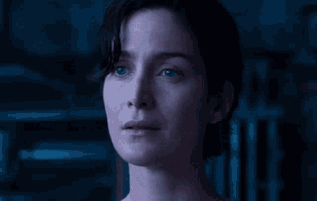 a close up of a woman 's face in a dark room