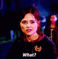 a woman is standing in a dark room and asking what .