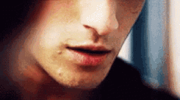 a close up of a man 's face with red lips and a beard .