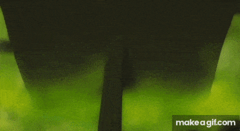 a person is standing in the dark with a blue light coming out of their chest .