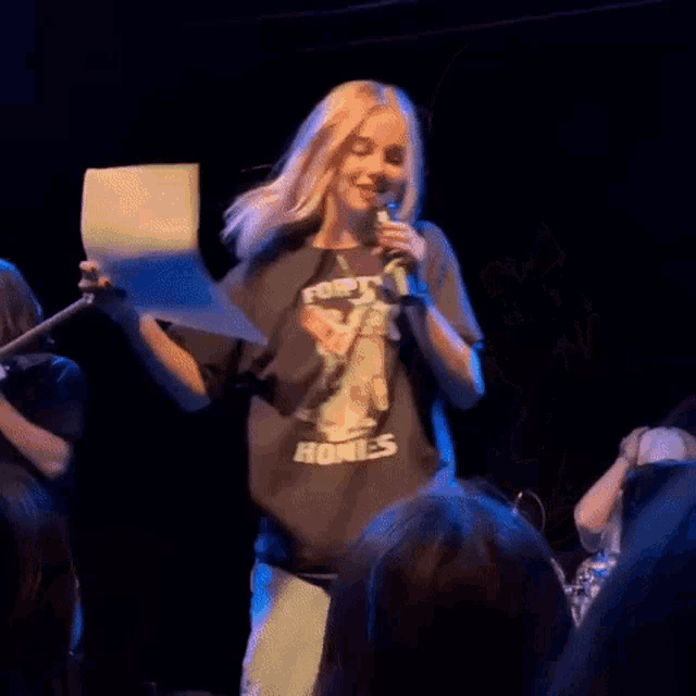 a blurry picture of a person holding a piece of paper in a dark room