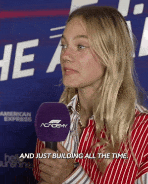 a woman talking into a microphone with the words and just building all the time