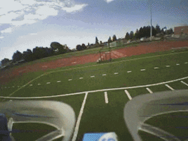 a drone is flying over a football field with a few lines on it