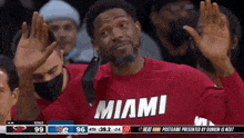 a man wearing a red miami shirt is waving