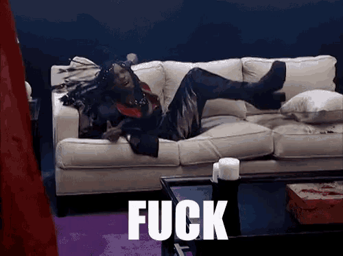 a person is laying on a couch with the word fuck written on it