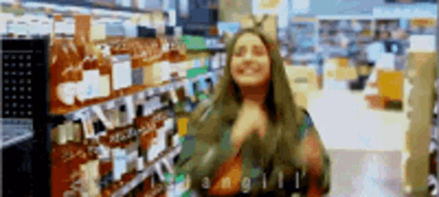 a woman is dancing in a grocery store while holding a bottle of wine .