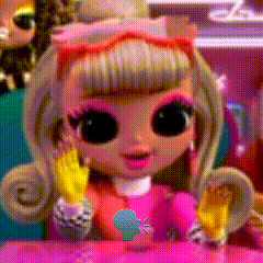 a doll with big eyes is sitting on a table with a blue fish sticker on it .
