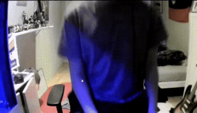 a person in a blue shirt is standing in front of a computer monitor