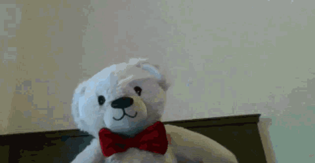 a teddy bear wearing a red bow tie