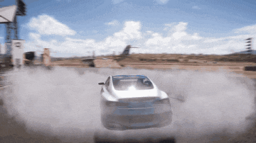 a white car is driving down a dirt road with smoke coming out of it