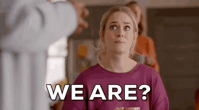 a woman is standing in front of a man and asking , `` we are ? '' .
