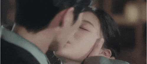 a man and a woman are kissing each other in a room .