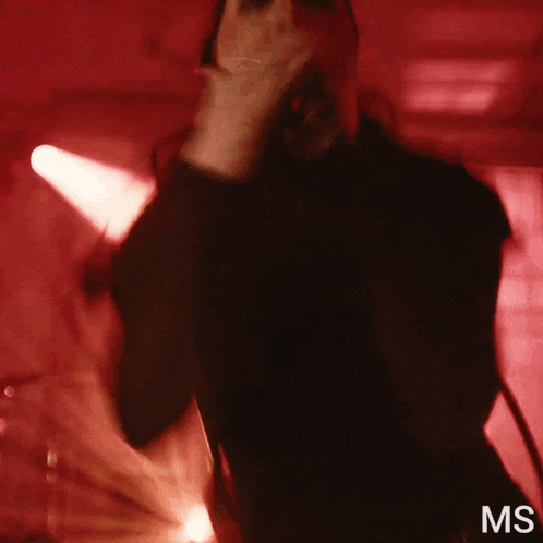 a man singing into a microphone with the letters ms visible in the corner
