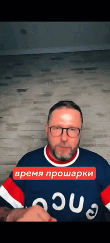 a man wearing glasses and a blue shirt that says ' aqua ' on it