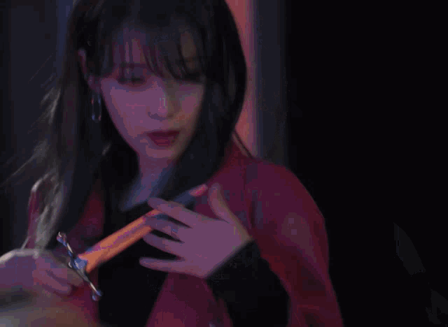 a woman in a red jacket holds a pair of scissors in her hand