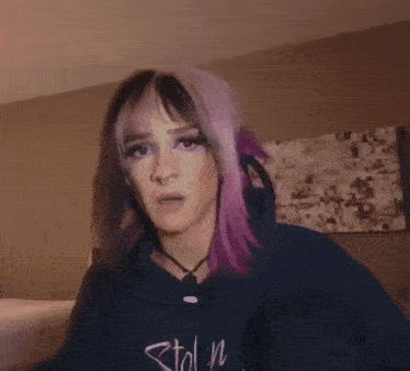 a woman with purple hair is dancing in a room .
