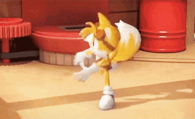 a toy sonic the hedgehog is dancing in front of a red barrel .
