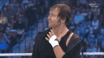 a man in a wrestling ring with his hand on his chest .