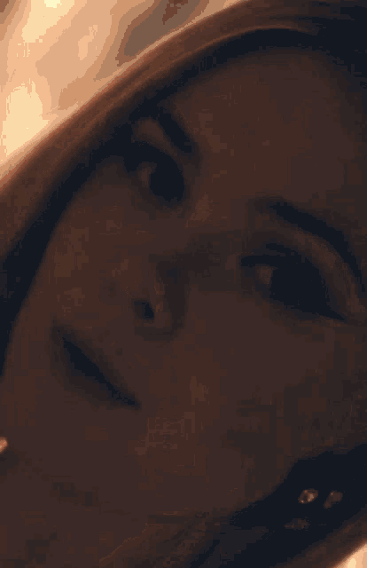 a close up of a woman 's face with a slight surprised look on her face