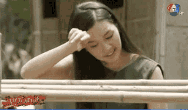 a woman wipes her forehead in front of a tv screen that says ' 7 ' on it