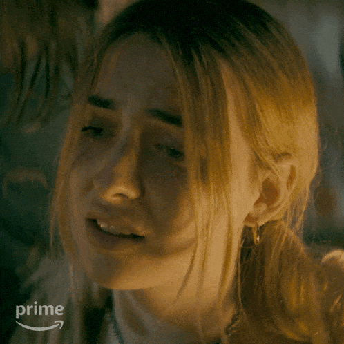 a close up of a woman 's face with a prime logo behind her