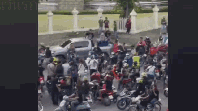 a large group of people are riding motorcycles on a street