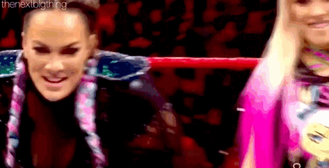 a couple of women are standing next to each other in a ring .
