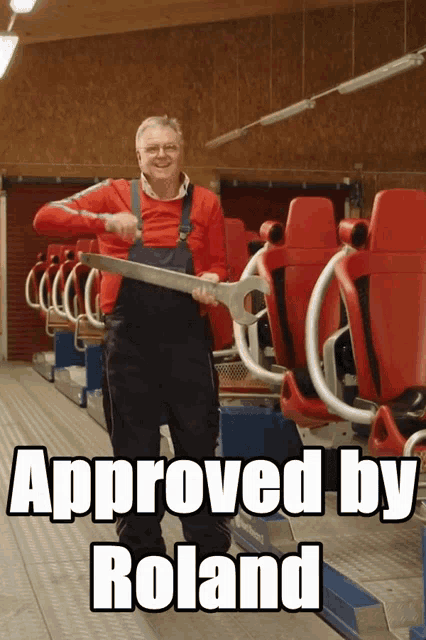 a man is holding a large wrench in front of a roller coaster and the caption says " approved by roland "