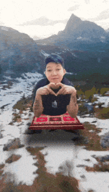 a person with a tattoo on their arm making a heart shape with their hands