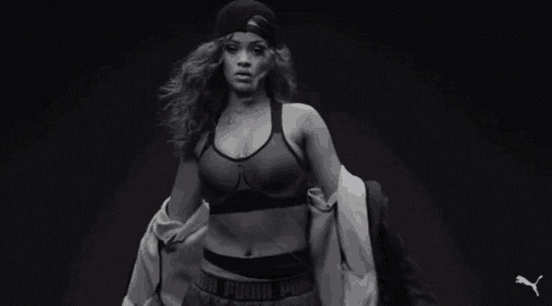a black and white photo of a woman wearing a hat and a bra that says puma