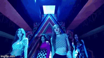 a group of women are standing next to each other in a dark room in front of a blue light .