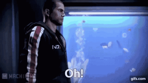 a man in a hoodie is standing in front of an aquarium and saying oh !