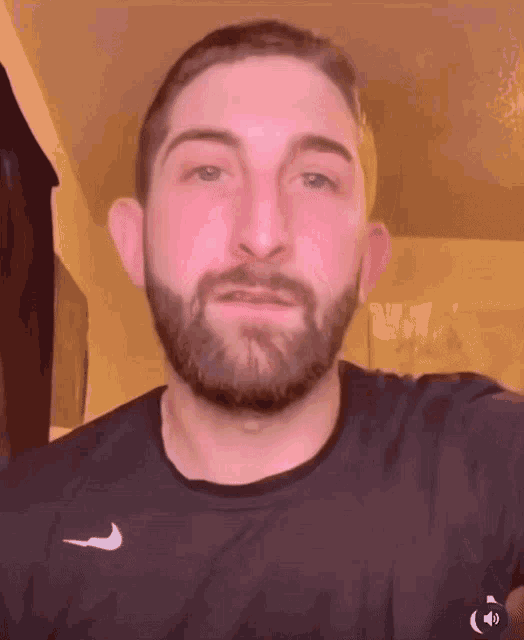 a man with a beard wearing a nike shirt