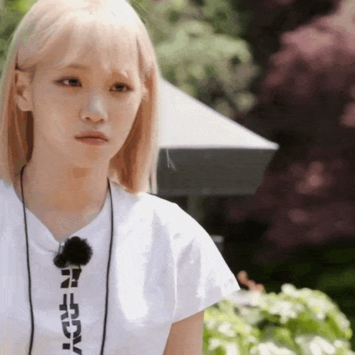 a girl with blonde hair is wearing a white t-shirt with the word adv on the front .