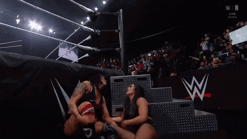 two women in a wrestling ring with a w on the bottom right