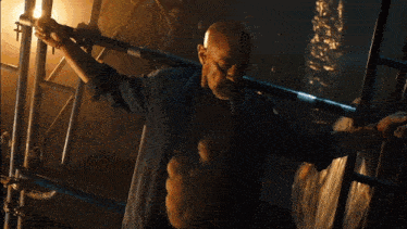 a man with a beard is holding a metal bar over his head