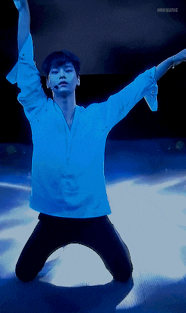 a man in a blue shirt is kneeling down with his arms out