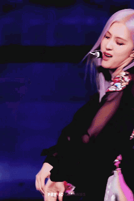 a woman with purple hair is wearing a black dress