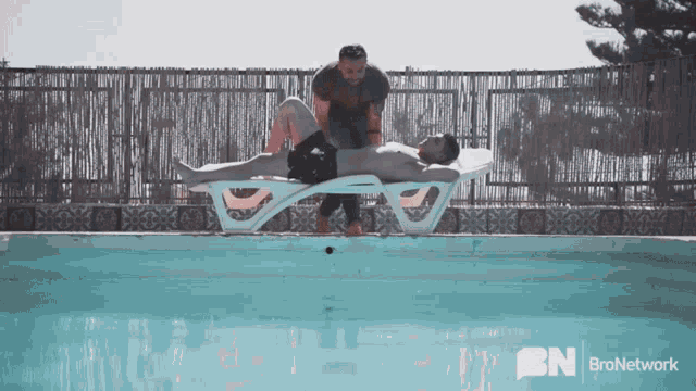 a man laying on a lounge chair next to a swimming pool with bronetwork written on the bottom right