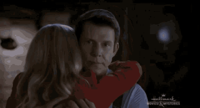 a woman is hugging a man from a hallmark movie