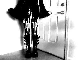 a black and white photo of a person standing in front of a white door