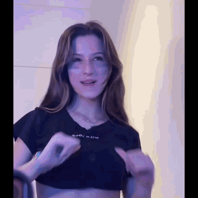 a young woman is wearing a black crop top with the word evo on it .